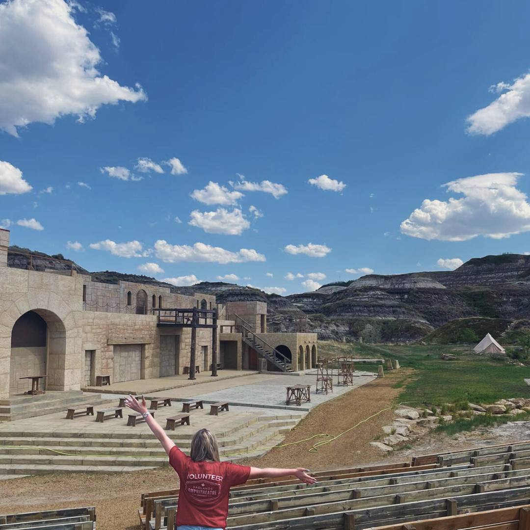 A volunteer stands in front of the Badlands Amphitheatre